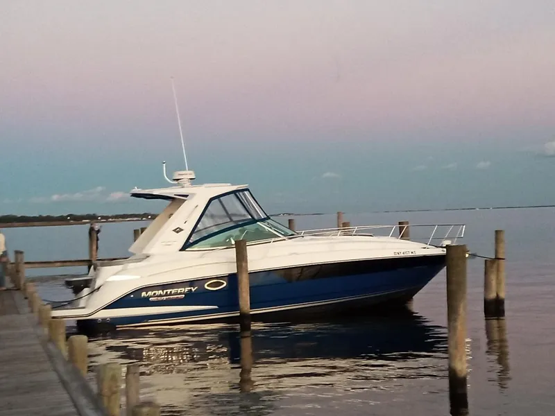 The Image of 2021 Monterey 335 Sport Yacht docked at sunset, calm waters reflecting the boat. - 0