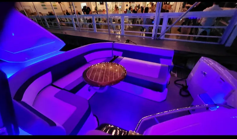 Slide: The Image of 2021 Monterey 335 Sport Yacht interior with blue LED lighting and circular wooden table. - 12