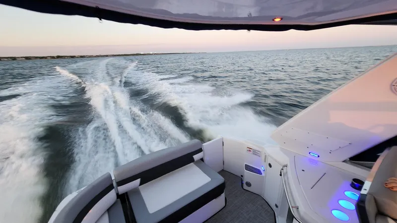 Slide: The Image of 2021 Monterey 335 Sport Yacht cruising on open water at sunset. - 13