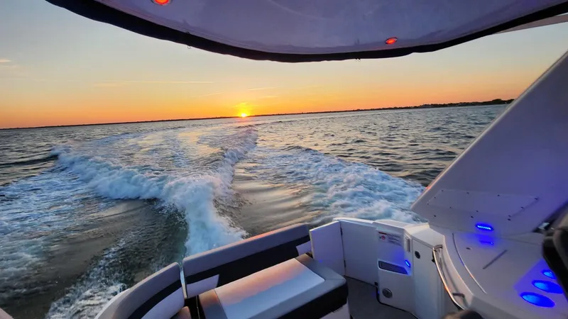 Slide: The Image of 2021 Monterey 335 Sport Yacht cruising at sunset, leaving a wake on the ocean. - 14