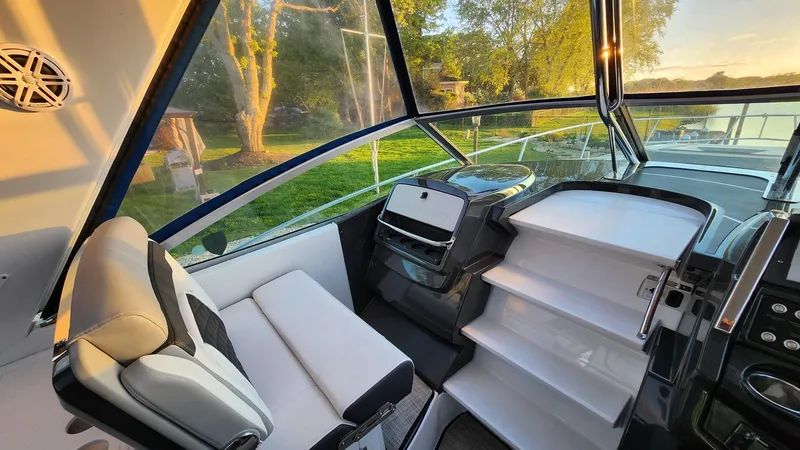 Slide: The Image of 2021 Monterey 335 Sport Yacht interior with modern seating and helm, surrounded by scenic views. - 18