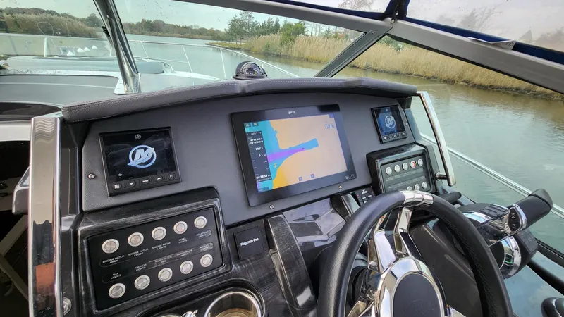 Slide: The Image of 2021 Monterey 335 Sport Yacht dashboard with navigation system on a calm waterway. - 22
