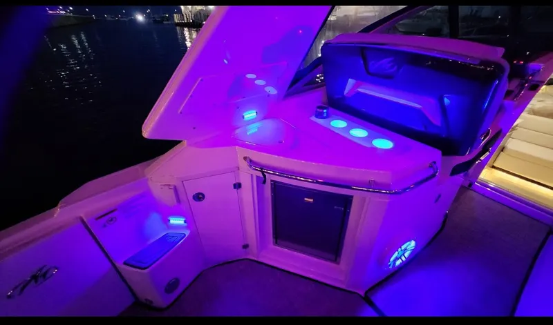 Slide: The Image of 2021 Monterey 335 Sport Yacht interior with vibrant blue LED lighting at night. - 28