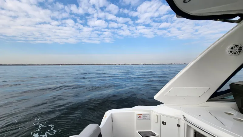 Slide: The Image of 2021 Monterey 335 Sport Yacht on calm water under a partly cloudy sky. - 7
