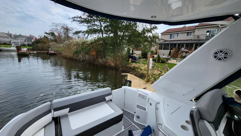 Slide: The Image of 2021 Monterey 335 Sport Yacht docked by a serene waterfront home. - 8