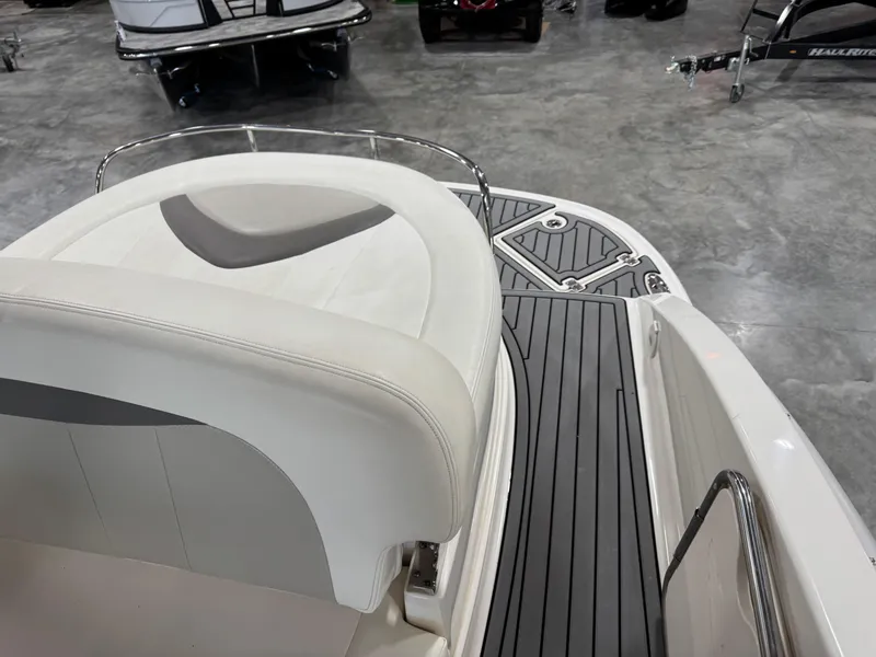 Slide: The Image of 2007 Chaparral 276 SSX boat interior with white seating and gray deck flooring. - 8