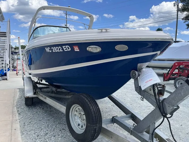 Slide: The Image of 2016 Regal 2000 ESX boat on trailer, blue hull, parked outdoors under a clear sky. - 19