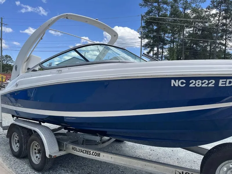 Slide: The Image of 2016 Regal 2000 ESX boat on trailer, blue and white design, clear sky background. - 20