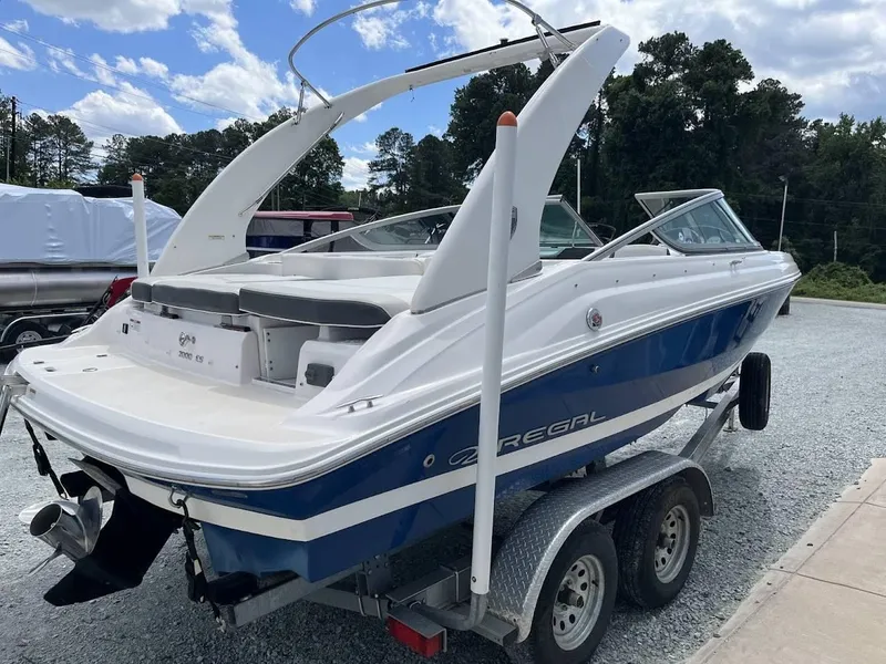 Slide: The Image of 2016 Regal 2000 ESX boat on trailer, blue and white design, parked outdoors. - 21