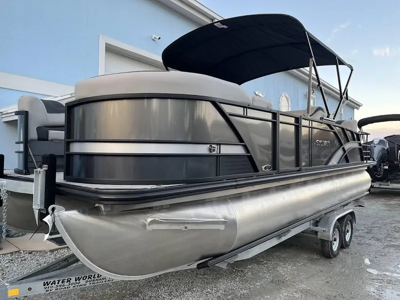 Slide: The Image of 2022 Sylvan L3 DLZ pontoon boat on trailer, featuring sleek design and canopy. - 16