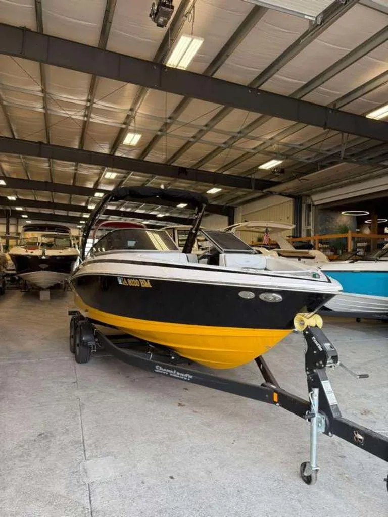Slide: The Image of 2014 Regal 2300 boat in storage, black and yellow hull, on trailer. - 1