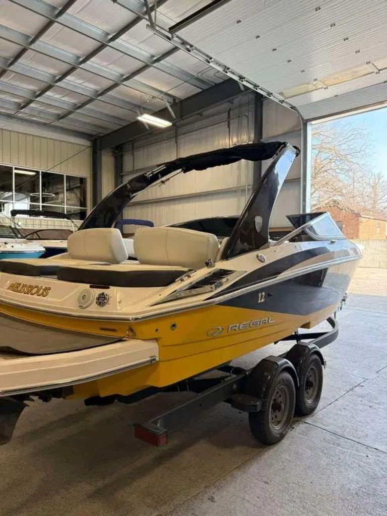 Slide: The Image of 2014 Regal 2300 boat on trailer in a garage setting. - 2