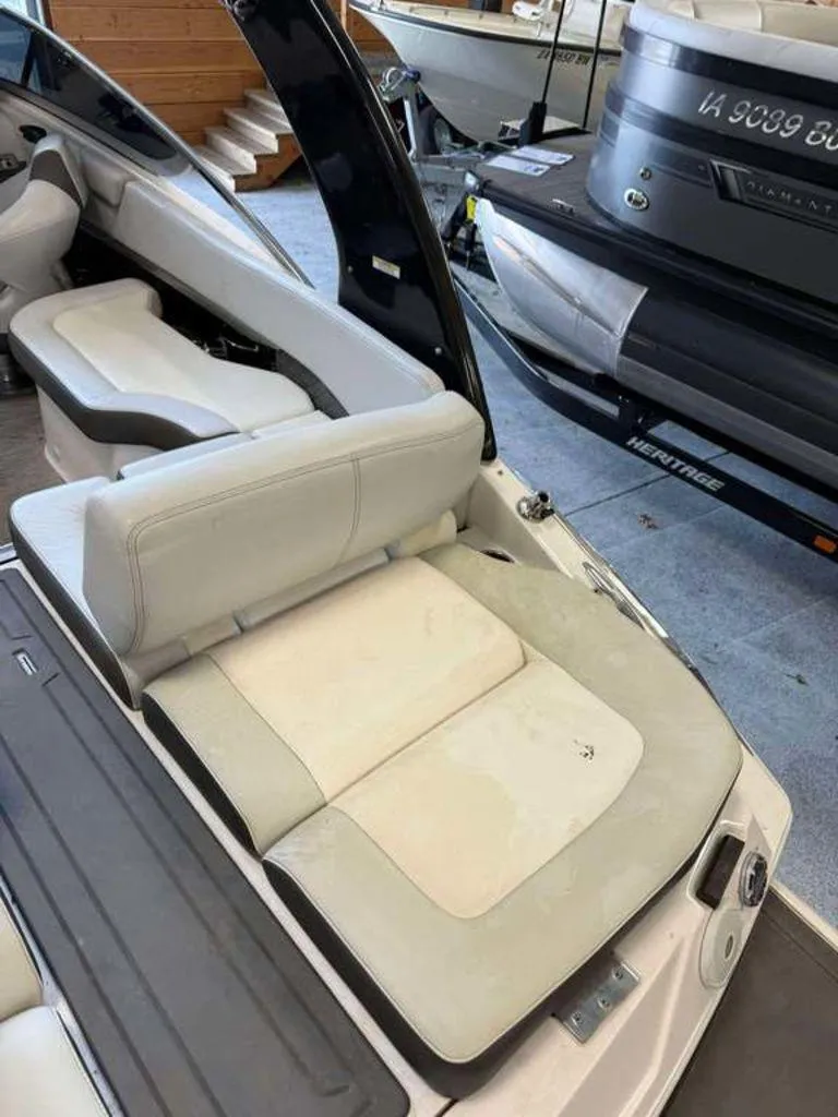 Slide: The Image of 2014 Regal 2300 boat interior with white seating and nearby docked boats. - 3