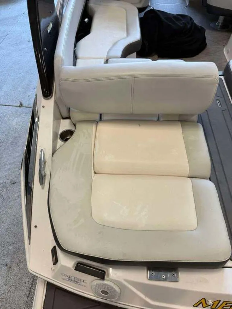 Slide: The Image of 2014 Regal 2300 boat interior with white cushioned seating and cup holder. - 7