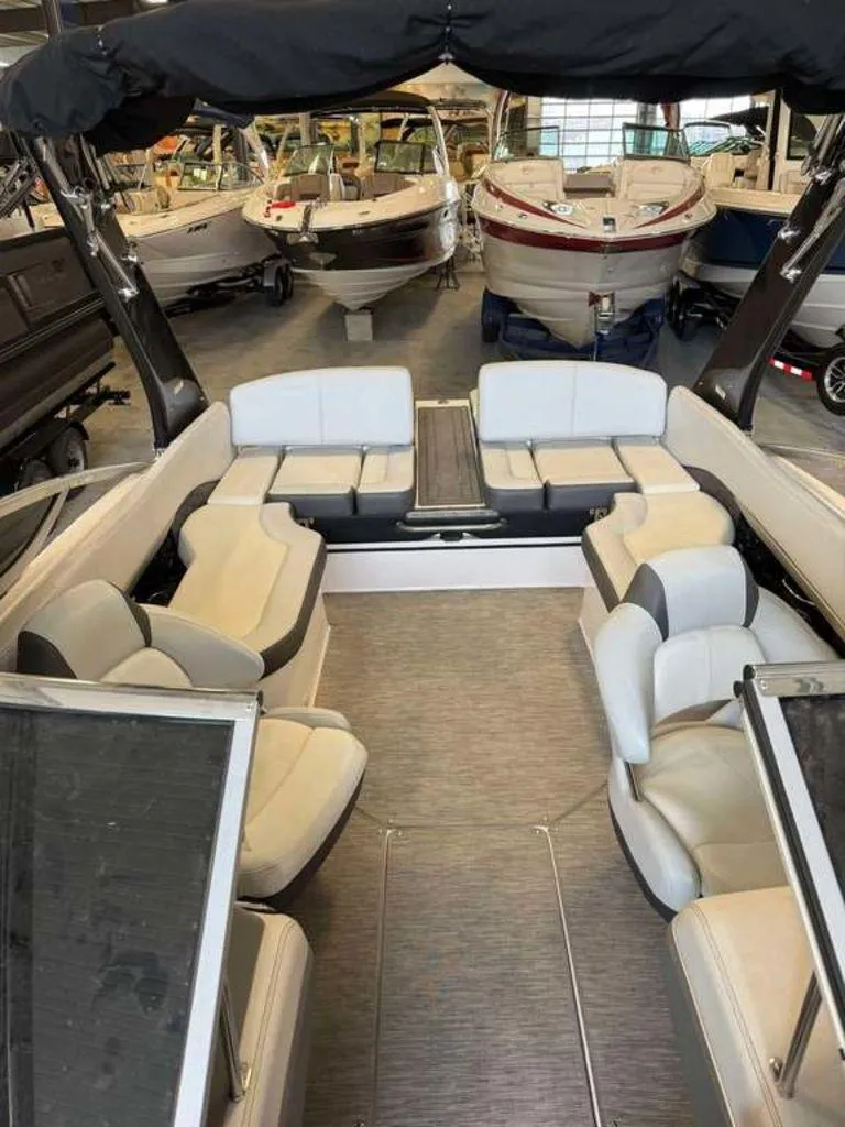Slide: The Image of 2014 Regal 2300 boat interior with spacious seating in a showroom. - 8