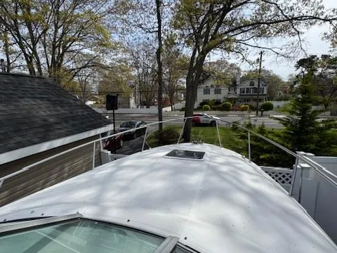 Slide: The Image of 2003 Sea Ray 280 Sundancer boat docked near residential area with trees and houses. - 14