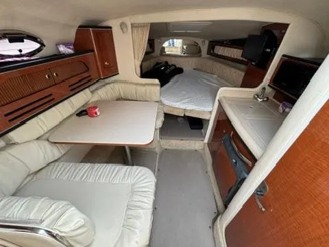 Slide: The Image of Interior of 2003 Sea Ray 280 Sundancer boat with seating, table, and bed. - 15