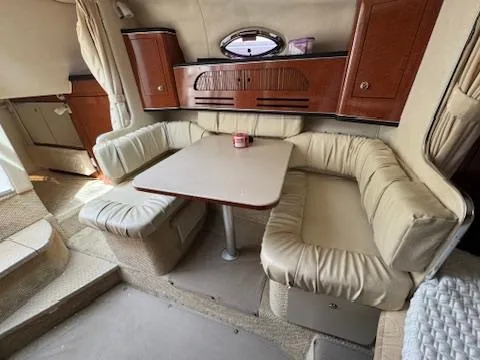 Slide: The Image of 2003 Sea Ray 280 Sundancer cabin with beige seating and wooden cabinetry. - 17