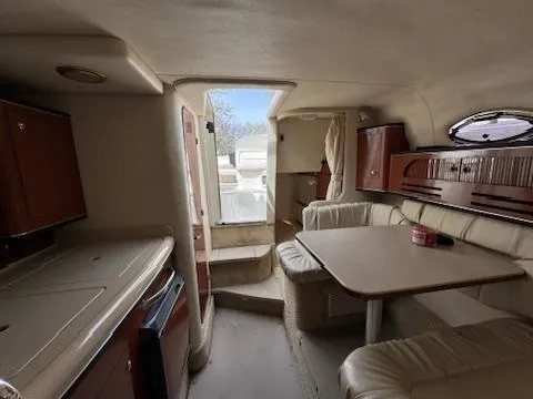 Slide: The Image of Interior of 2003 Sea Ray 280 Sundancer boat with seating and kitchenette. - 18