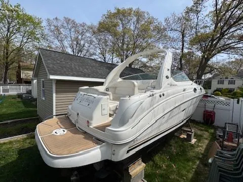 Slide: The Image of 2003 Sea Ray 280 Sundancer boat on land, near a house and trees. - 4