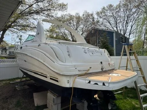 Slide: The Image of 2003 Sea Ray 280 Sundancer boat on blocks in a yard, ready for maintenance. - 5