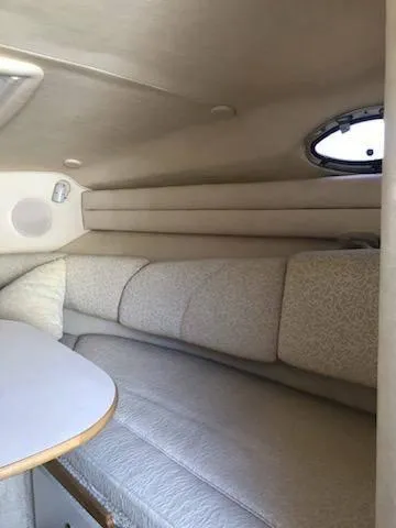 Slide: The Image of Interior of a 2001 Sea Ray 260DA boat, featuring a cozy seating area. - 12