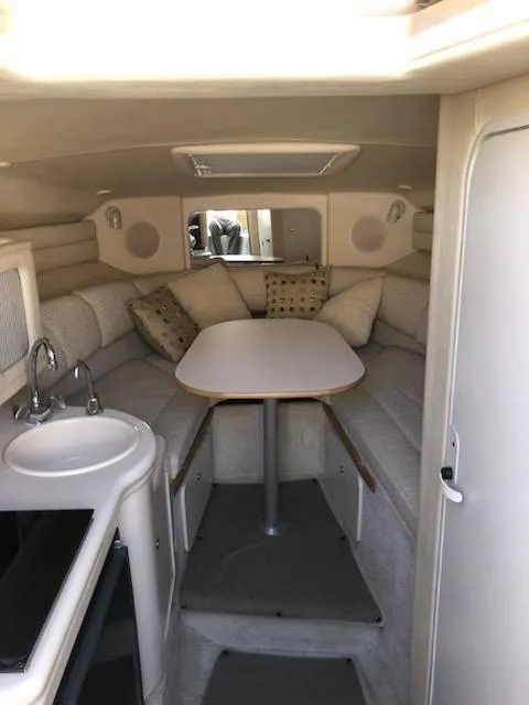 Slide: The Image of Interior of 2001 Sea Ray 260DA boat with cozy seating and compact kitchenette. - 13