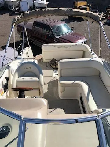 Slide: The Image of 2001 Sea Ray 260DA boat with spacious seating and canopy, parked near a truck. - 17