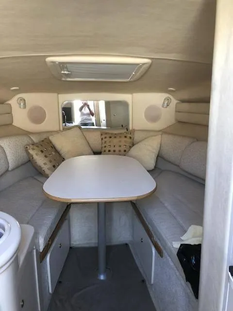 Slide: The Image of 2001 Sea Ray 260DA cabin interior with cozy seating and table setup. - 18