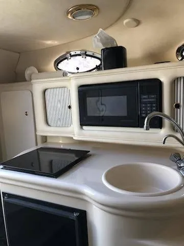 Slide: The Image of 2001 Sea Ray 260DA boat kitchenette with microwave, sink, and stove. - 20