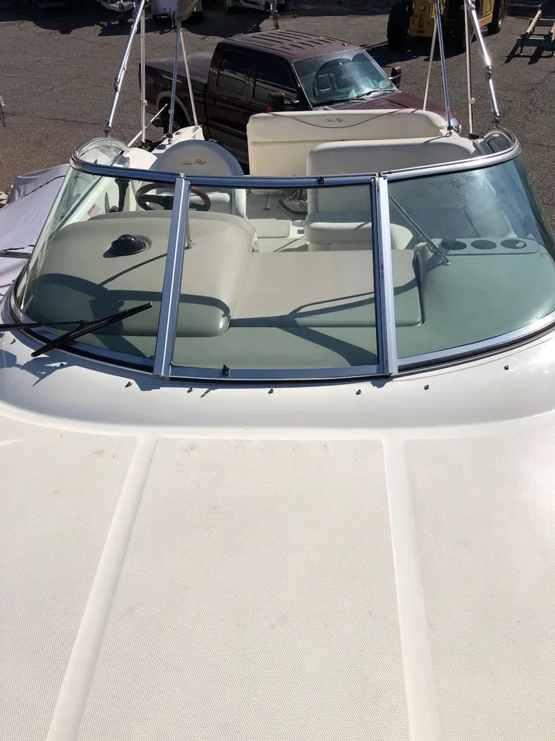 Slide: The Image of 2001 Sea Ray 260DA boat with windshield and seating, parked outdoors. - 4
