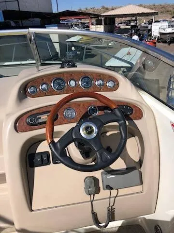 Slide: The Image of 2001 Sea Ray 260DA boat dashboard with wood accents and steering wheel. - 5