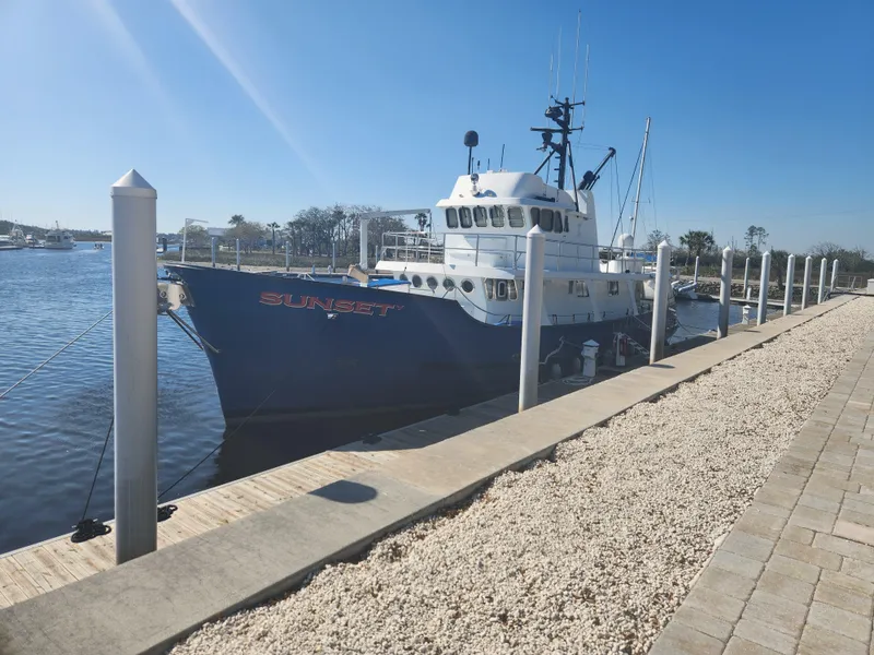 Slide: The Image of 1983 Custom 76 Trawler docked at a marina on a sunny day. - 0