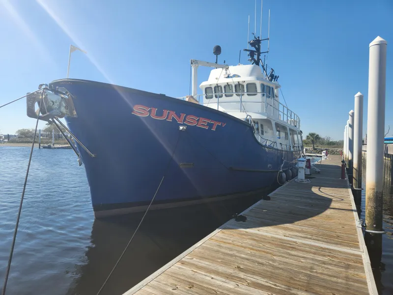 Slide: The Image of Custom 1983 76 Trawler "Sunset" docked at marina under clear blue sky. - 1