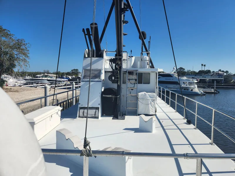 Slide: The Image of 1983 Custom 76 Trawler docked at marina under clear blue sky. - 11
