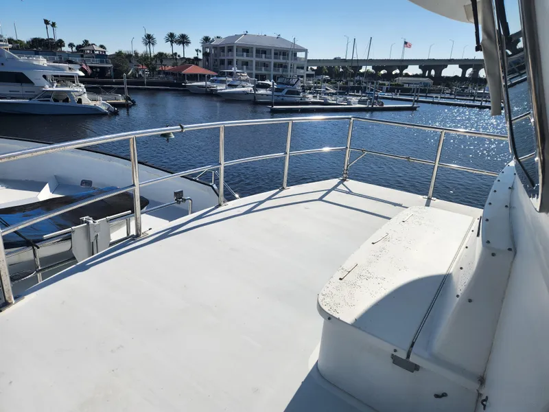 Slide: The Image of 1983 Custom 76 Trawler deck overlooking marina with boats and waterfront buildings. - 14