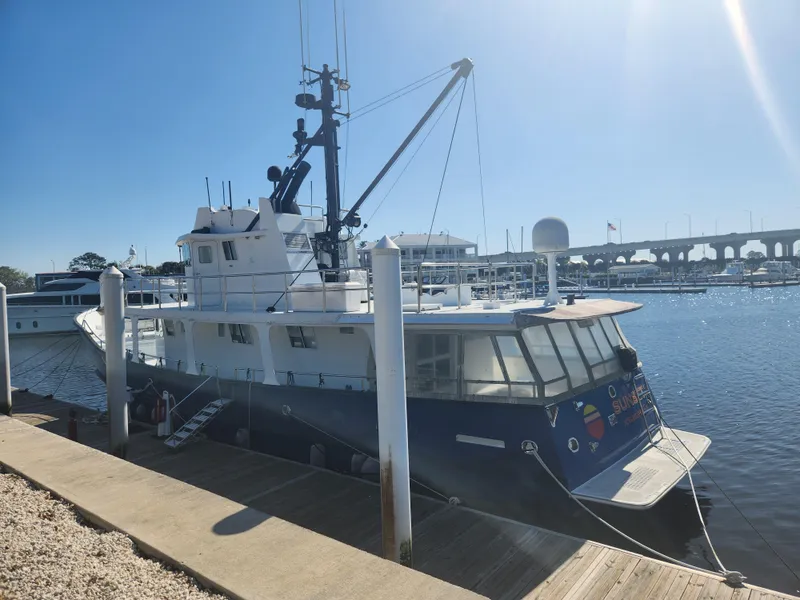 Slide: The Image of Custom 1983 76 Trawler docked at marina under clear blue sky. - 2