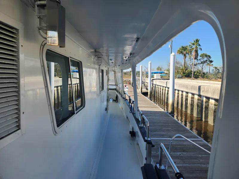 Slide: The Image of Side view of a 1983 Custom 76 Trawler docked at a marina. - 20