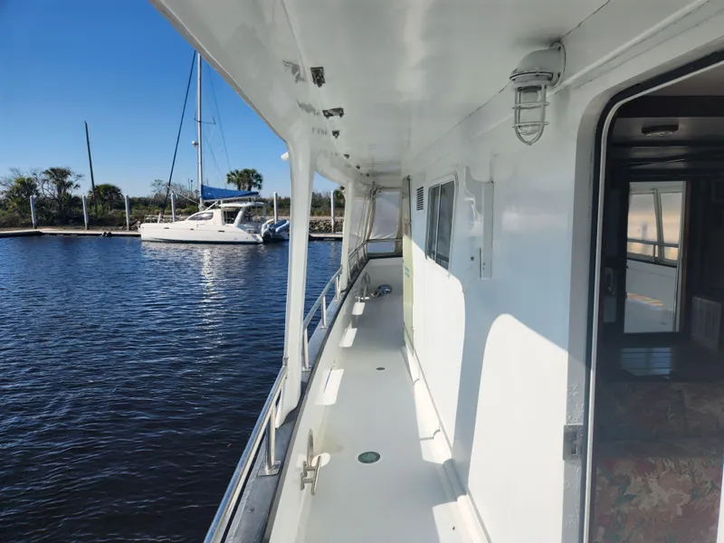 Slide: The Image of Side deck of 1983 Custom 76 Trawler with marina view and clear blue sky. - 21