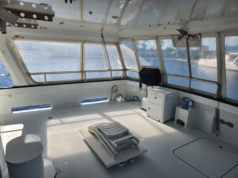 Slide: The Image of Spacious interior of 1983 Custom 76 Trawler with panoramic windows and seating area. - 27