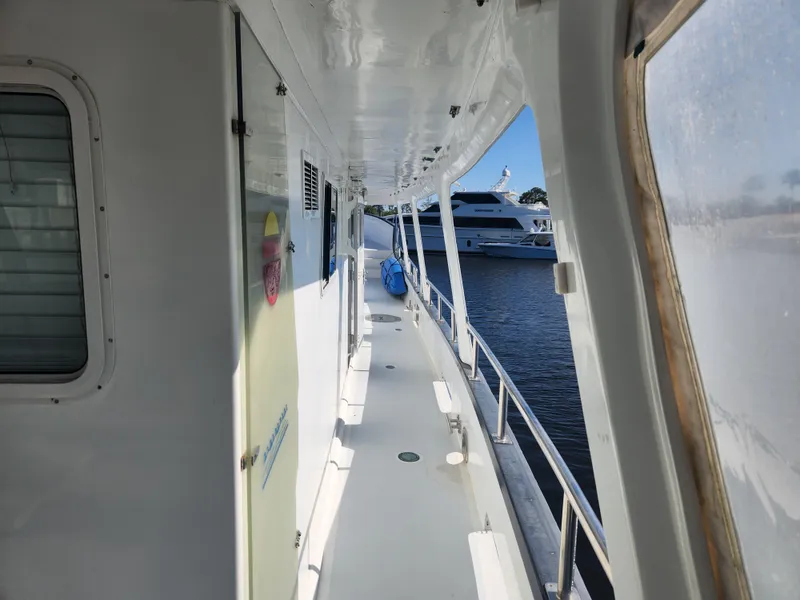 Slide: The Image of Side deck of a 1983 Custom 76 Trawler, docked with a view of another yacht. - 30