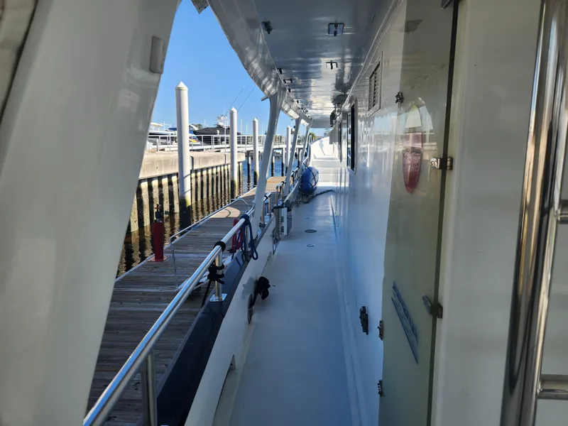 Slide: The Image of Side deck view of a 1983 Custom 76 Trawler docked at a marina. - 31