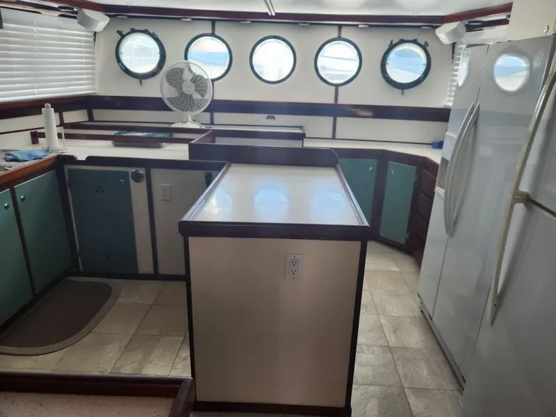 Slide: The Image of Interior of 1983 Custom 76 Trawler kitchen with porthole windows and modern appliances. - 34