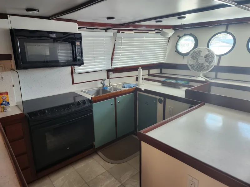 Slide: The Image of 1983 Custom 76 Trawler kitchen with modern appliances and porthole windows. - 35