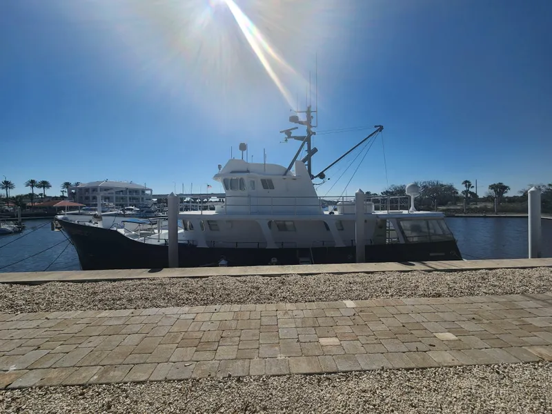 Slide: The Image of Custom 76 Trawler, 1983 model, docked under a bright sunlit sky. - 4