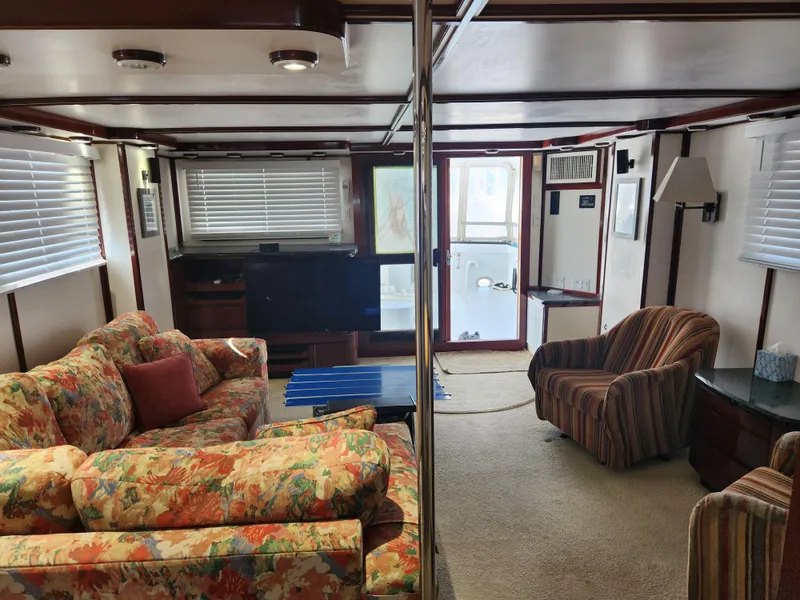 Slide: The Image of Interior of 1983 Custom 76 Trawler with floral sofas and striped armchair. - 43