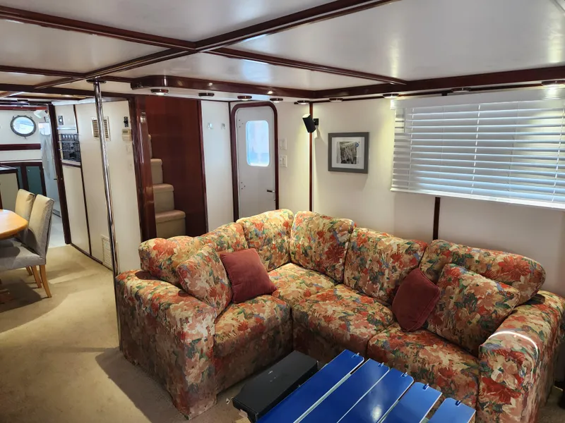 Slide: The Image of Interior of 1983 Custom 76 Trawler with floral sofa and dining area. - 44