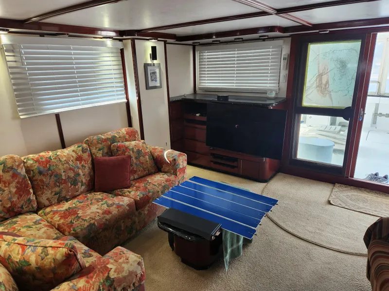 Slide: The Image of Interior of 1983 Custom 76 Trawler with floral sofa, blue table, and window blinds. - 45