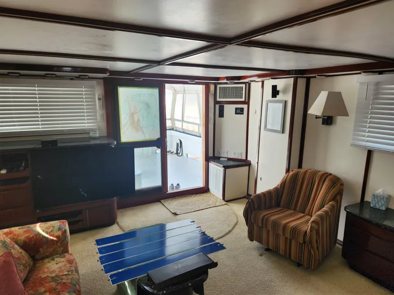 Slide: The Image of Interior of 1983 Custom 76 Trawler with cozy seating, striped chair, and nautical decor. - 47