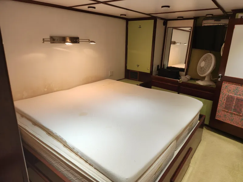 Slide: The Image of Cozy bedroom interior of 1983 Custom 76 Trawler with bed, lighting, and fan. - 49